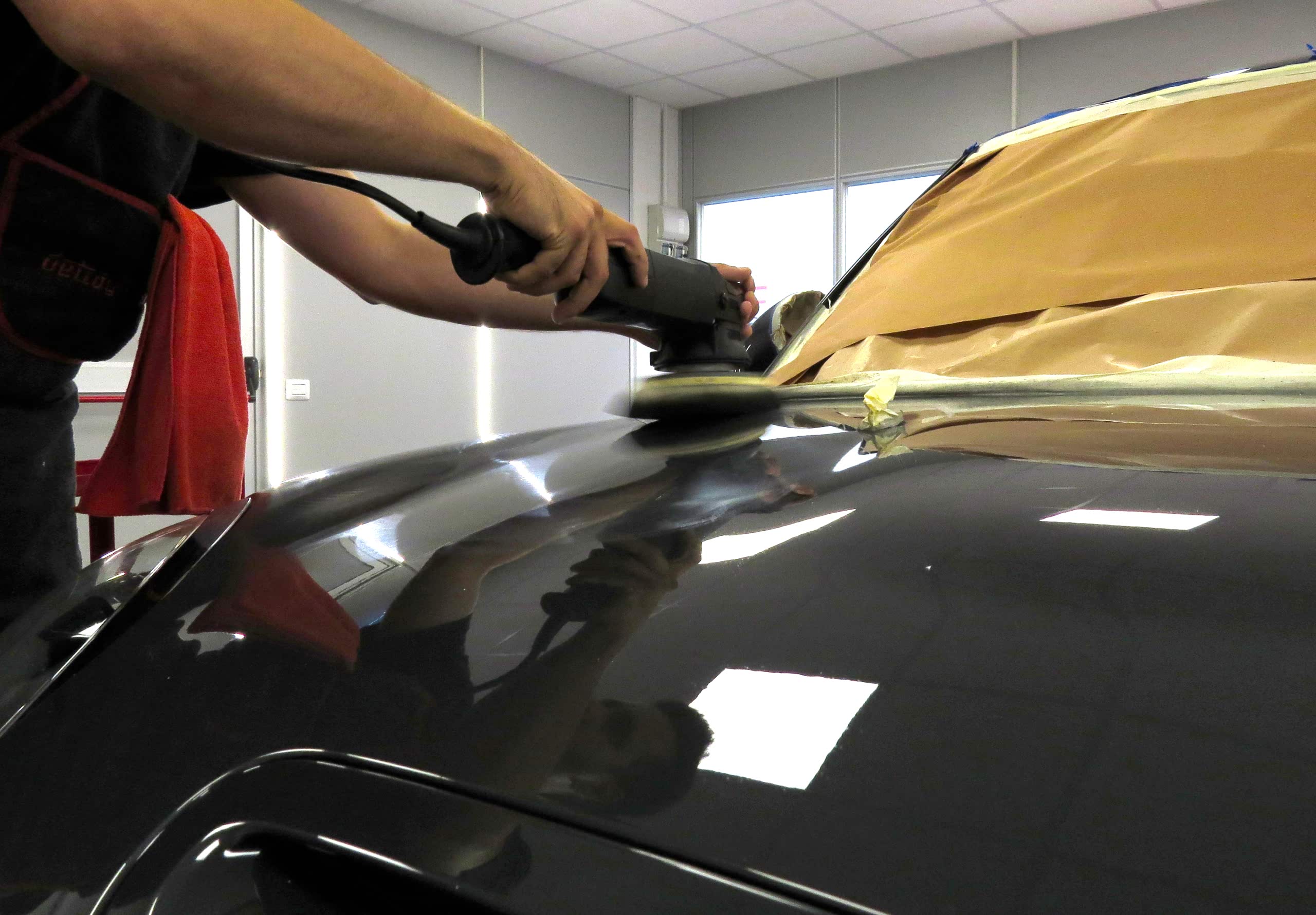 Employee performing a car polishing service